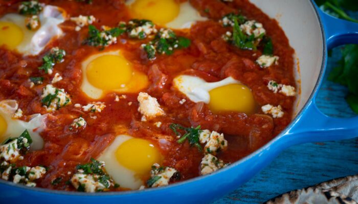 Shakshuka with poached eggs in a blue skillet